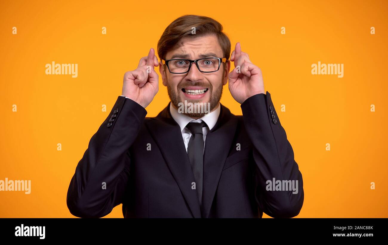 Imprenditore superstizioso incrocio le dita per la buona fortuna, sperando di vincere, fortune Foto Stock