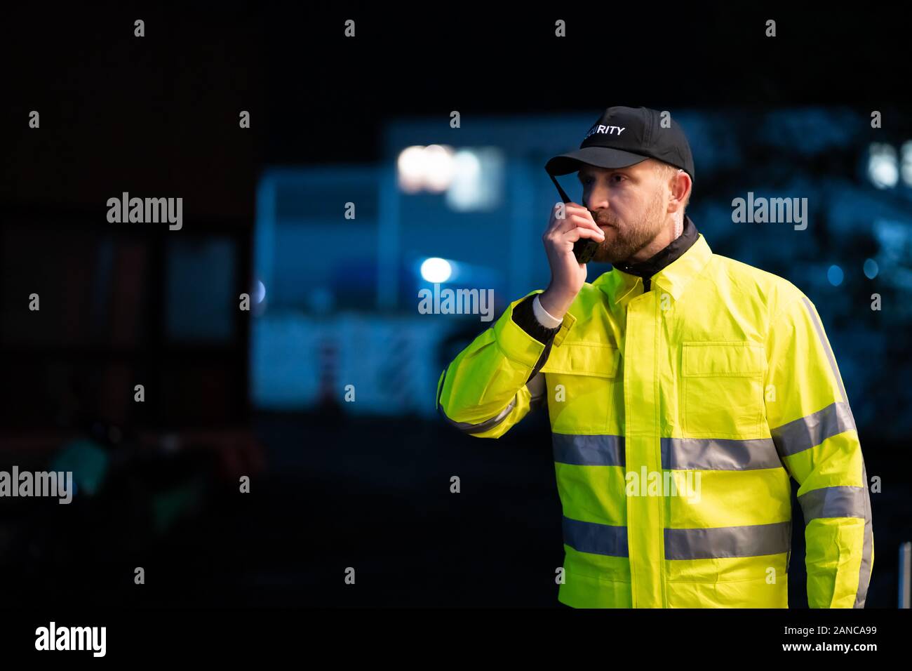 Ritratto di giovane guardia di sicurezza utilizzando un walkie-talkie Radio Foto Stock