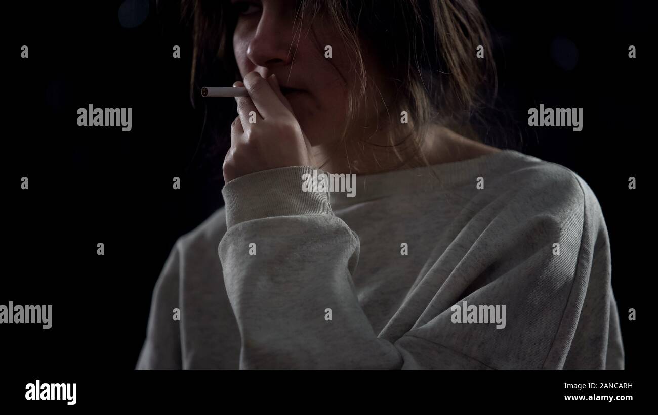 Sottolineato giovane donna di fumare sigarette, malsana abitudine, tossicodipendenza closeup Foto Stock