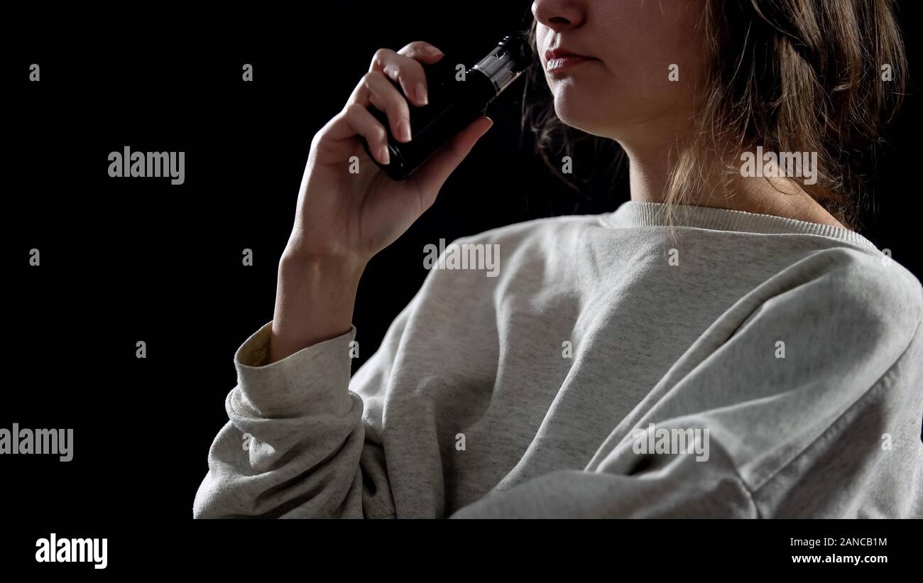 Giovane donna con la sigaretta elettronica, dispositivo per la simulazione di fumo, vapore Foto Stock