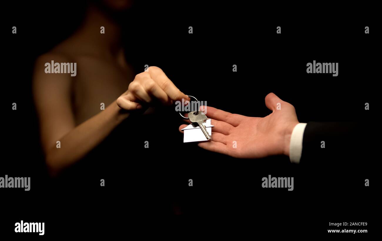 Uomo Donna che dà le chiavi di casa con portachiavi, presente per la Mistress, barare Foto Stock