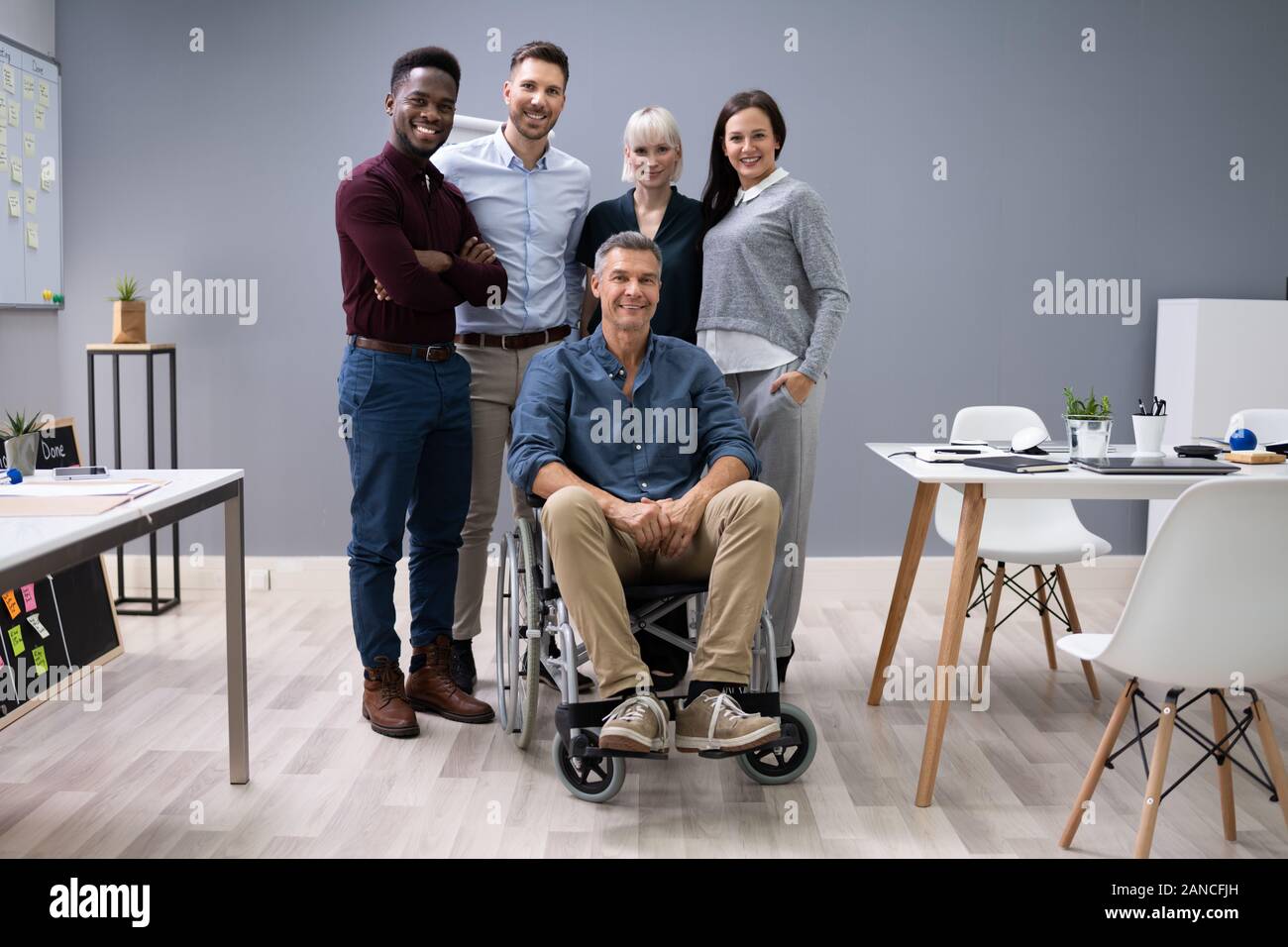 Gruppo di Felice imprenditori e multirazziale in piedi in ufficio Foto Stock