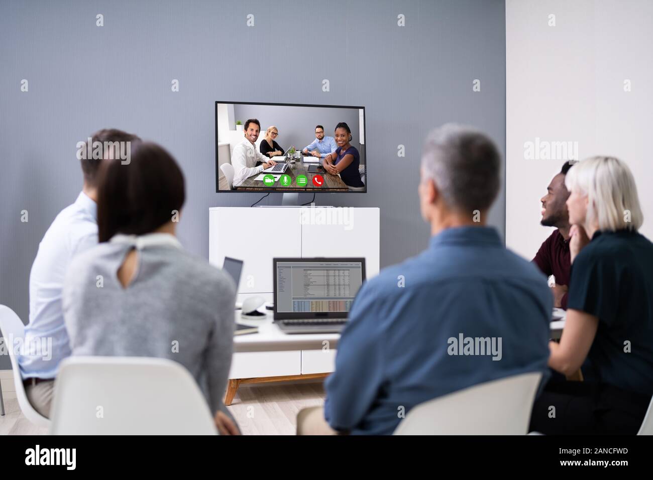 Un gruppo di imprenditori aventi Video conferenza nella sala riunioni Foto Stock