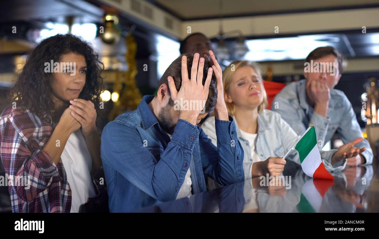 Triste e multirazziale italiani appassionati di sport con bandiera delusa della sconfitta nel confronto Foto Stock