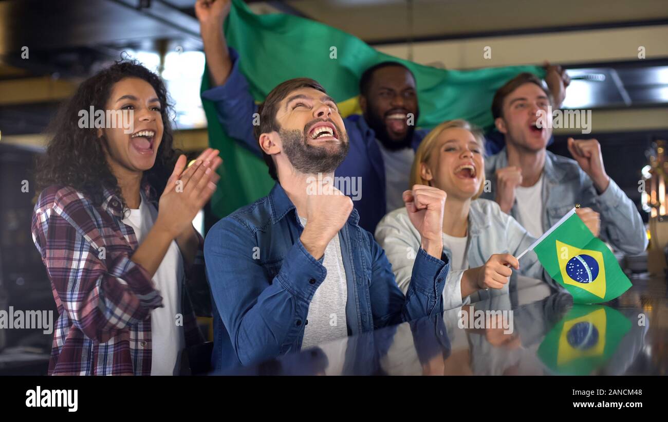 Estremamente felici i fan dello sport sventola Bandiera Brasile a sostegno della squadra nazionale Foto Stock