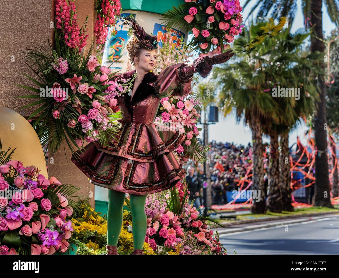 Artista che lancia fiori da galleggiare alla folla al Flower Parade, Nizza Carnevale, Costa Azzurra, Costa Azzurra, Francia. Foto Stock