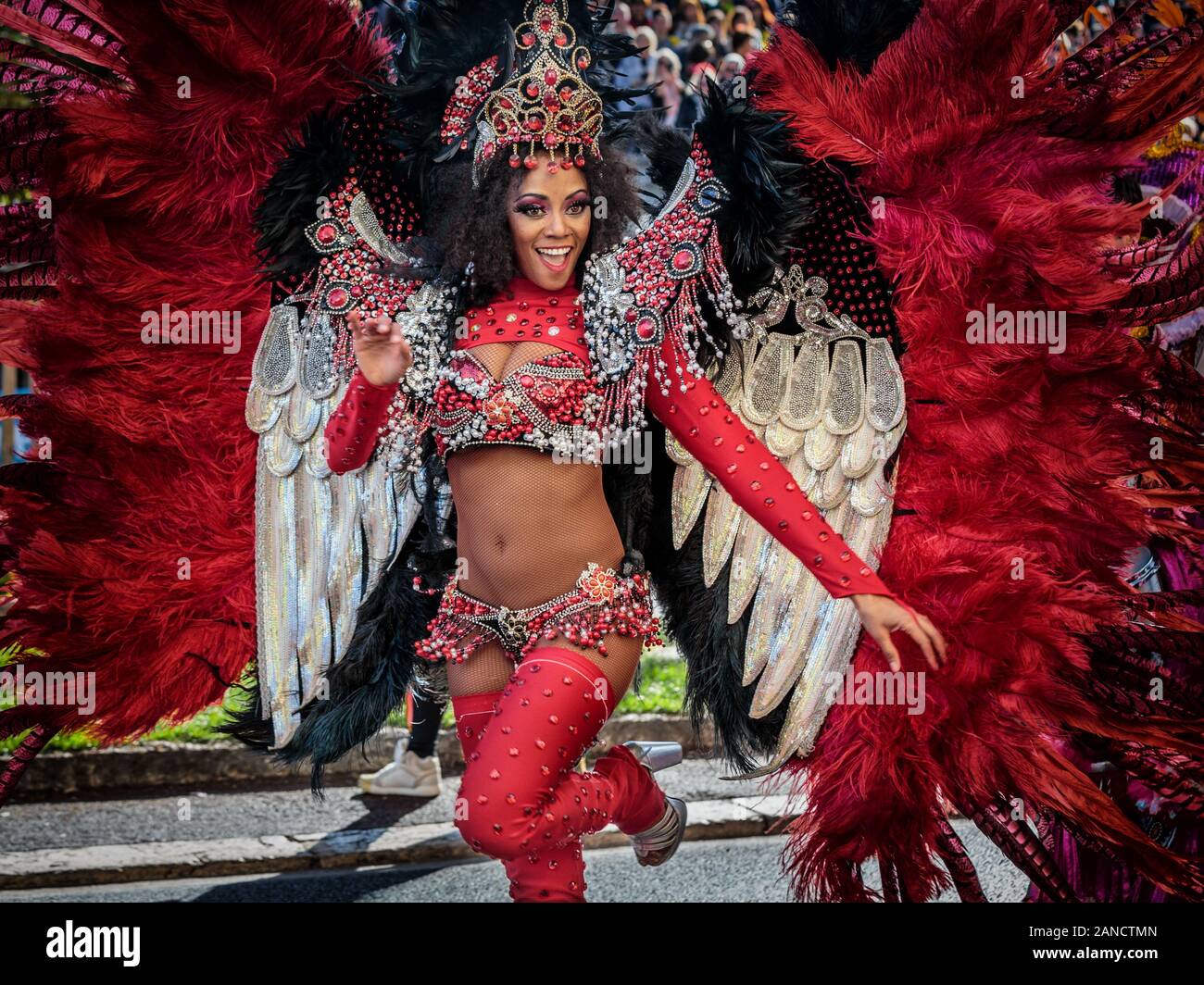 Performer in costume dai colori vivaci con ali e piume alla Flower Parade, Nizza Carnevale, Costa Azzurra, Costa Azzurra, Francia. Foto Stock