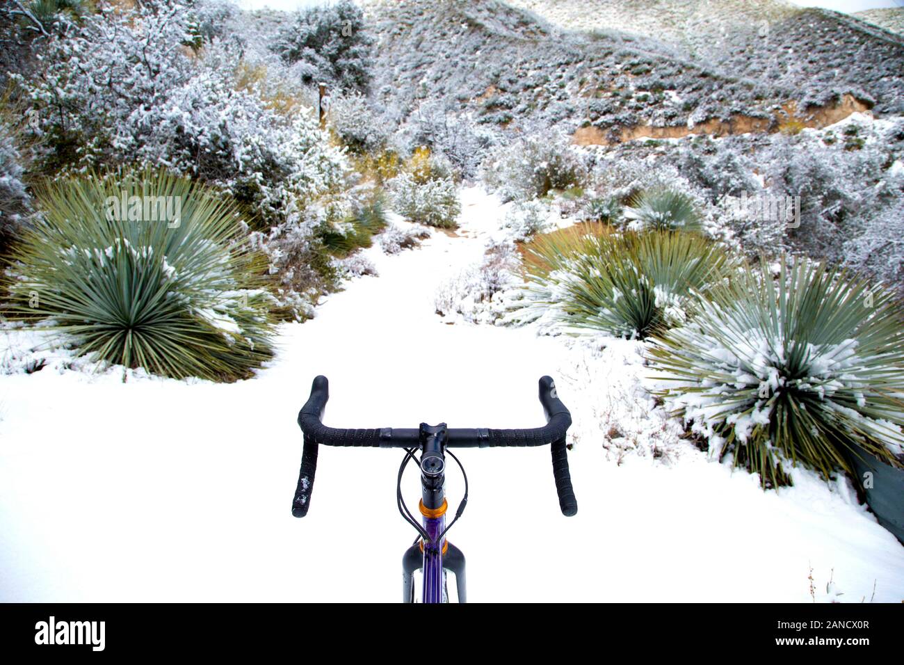 bicicletta su sentiero innevato deserto di montagna Foto Stock