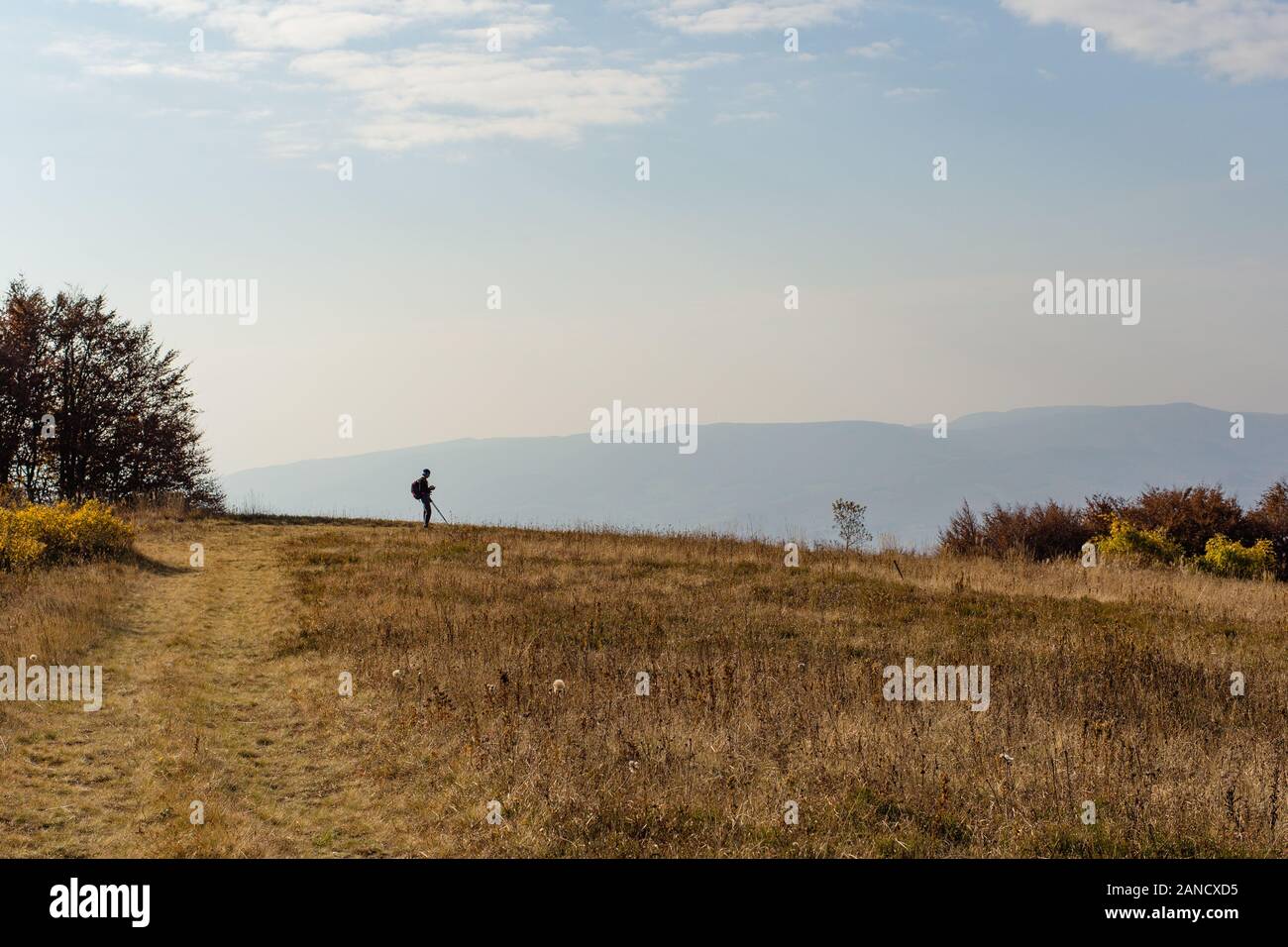 Silhouette di un uomo in piedi in montagna. Sfondo blu cielo Foto Stock