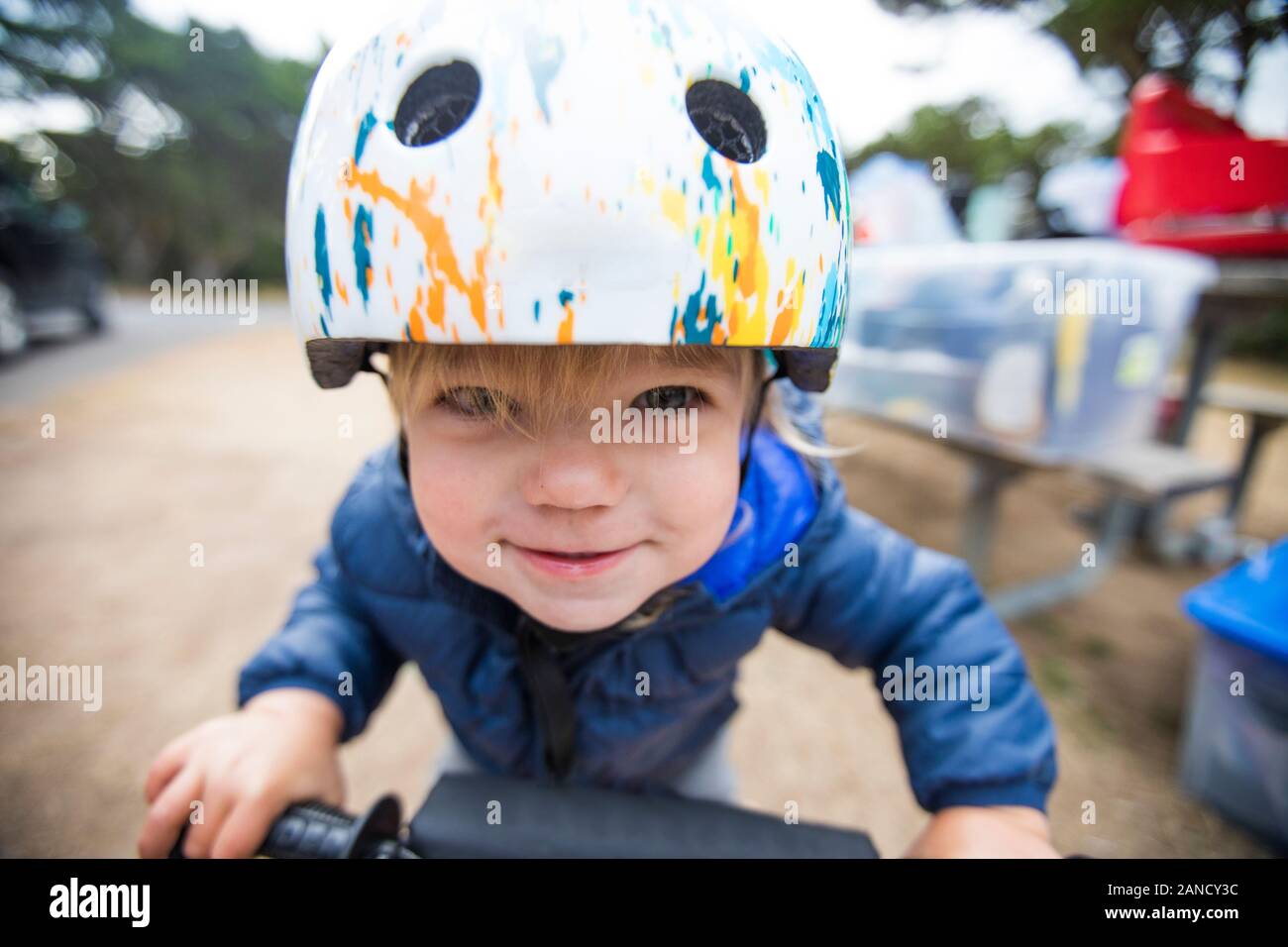 Una ragazza di un anno in bicicletta con determinazione. Foto Stock