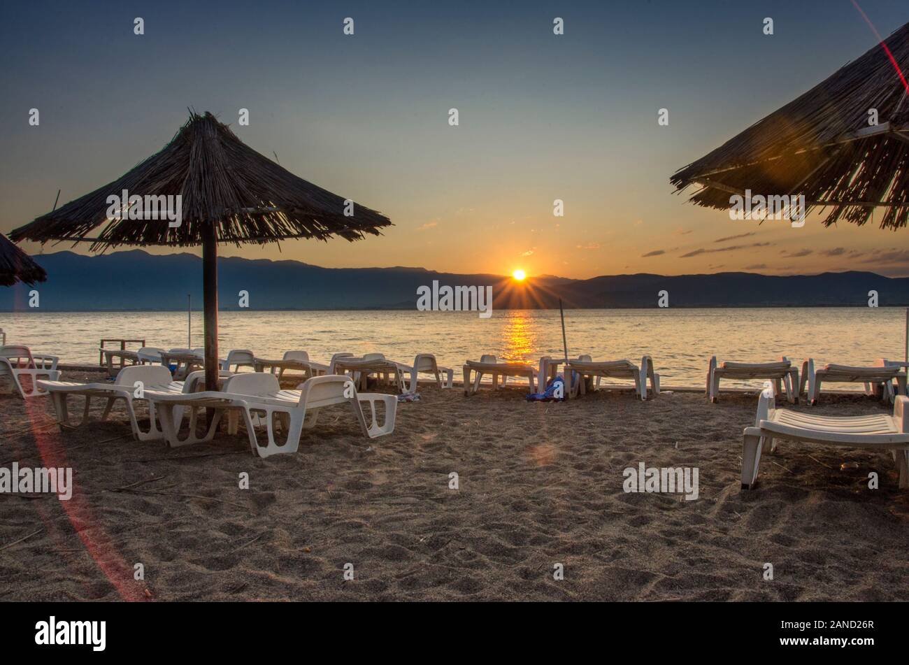 Dojran, Macedonia - Sunrise scena - ombrelloni sulla spiaggia Foto Stock