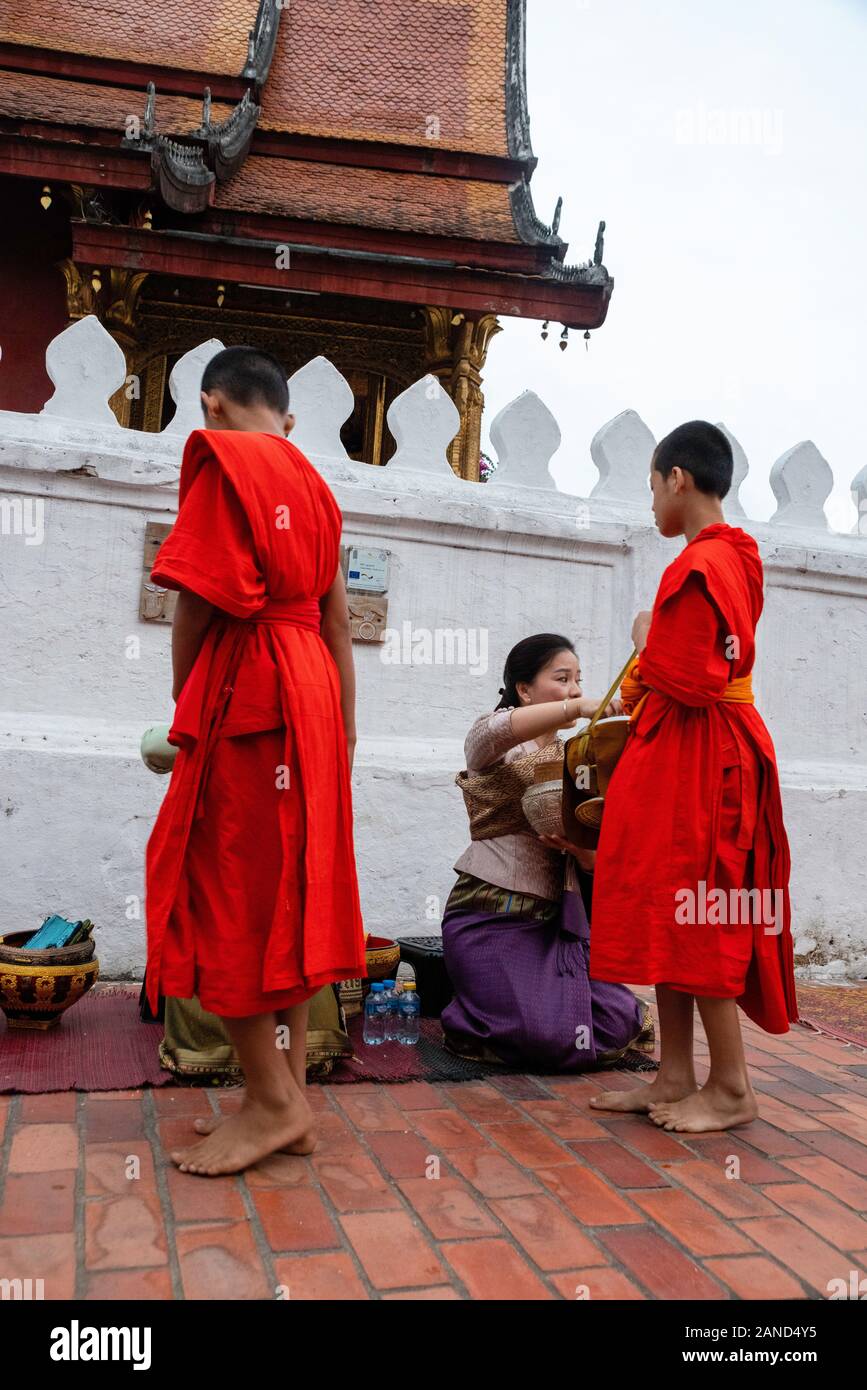 I monaci e i turisti partecipare a sai bat (mattina alms dando), Luang Prabang, Laos. Foto Stock