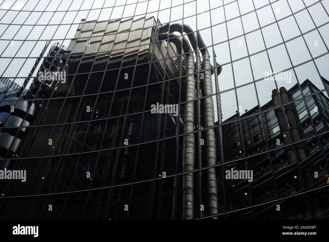 Lloyd's of London insolita vista del futuristico Lloyd's Building riflessa dalla facciata in vetro del Willis Towers Watson Building nella City of London UK Foto Stock