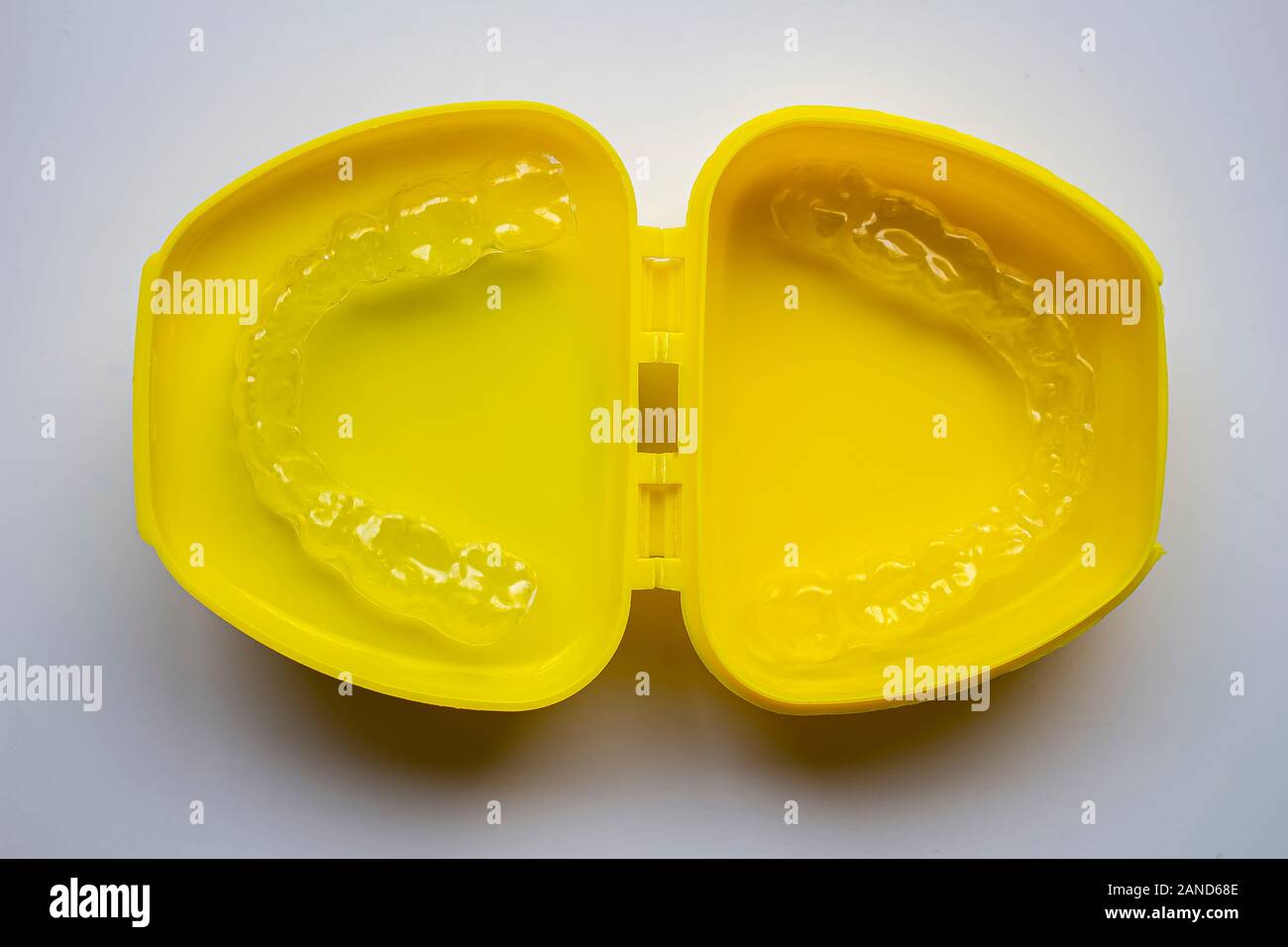 Protezione bocca su un caso di colore giallo con sfondo bianco Foto Stock