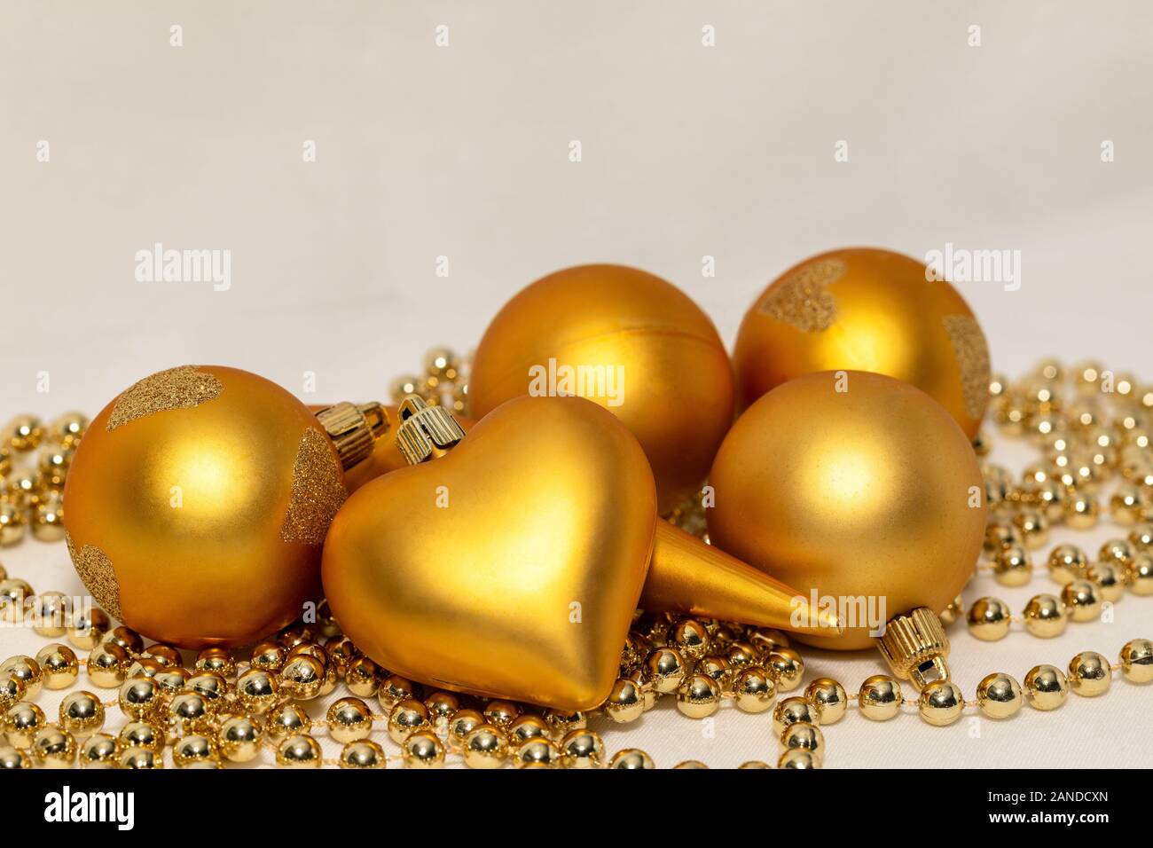 Decorazioni natalizie di colore oro su sfondo bianco Foto Stock