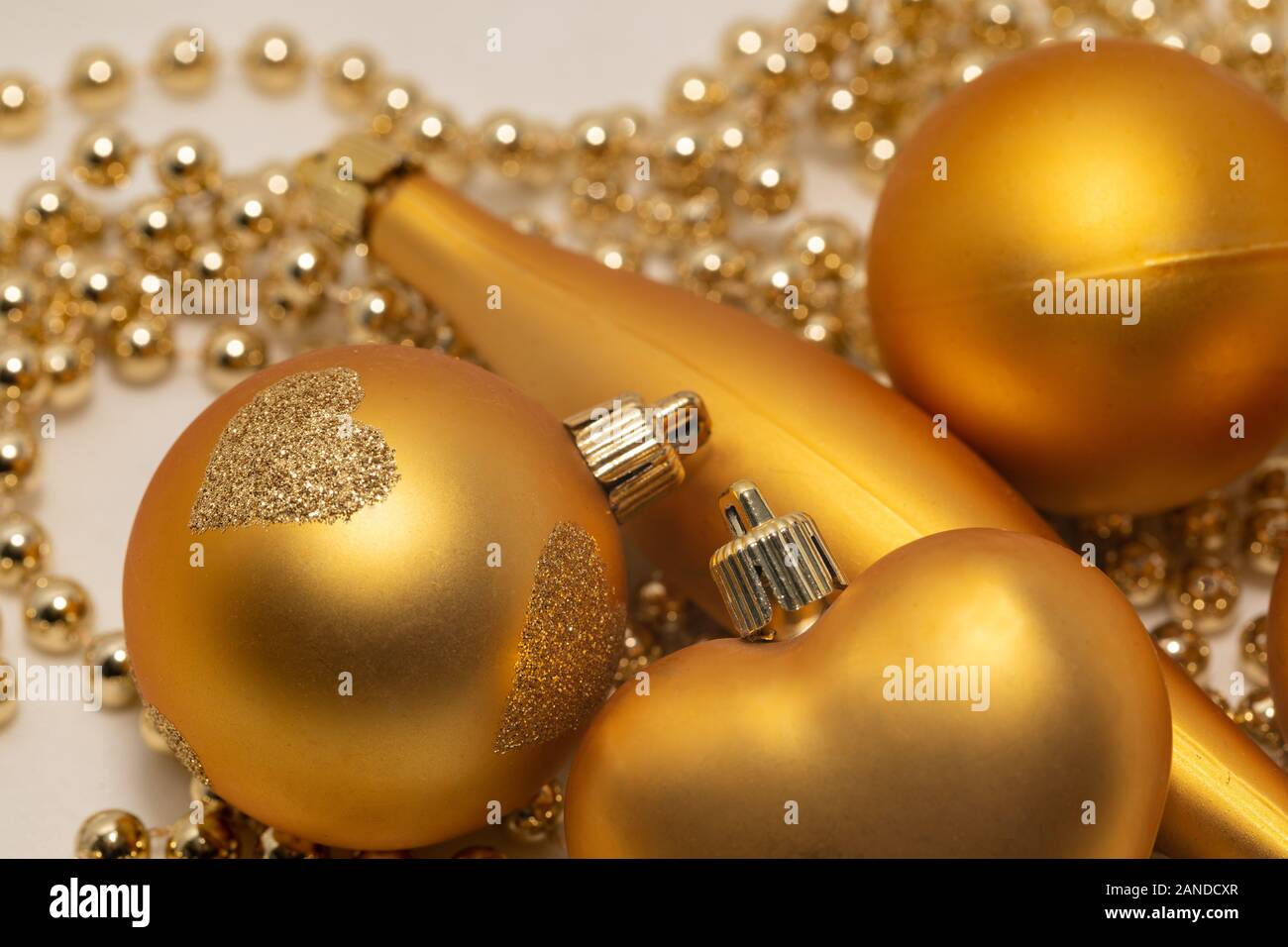Decorazioni natalizie di colore oro su sfondo bianco Foto Stock