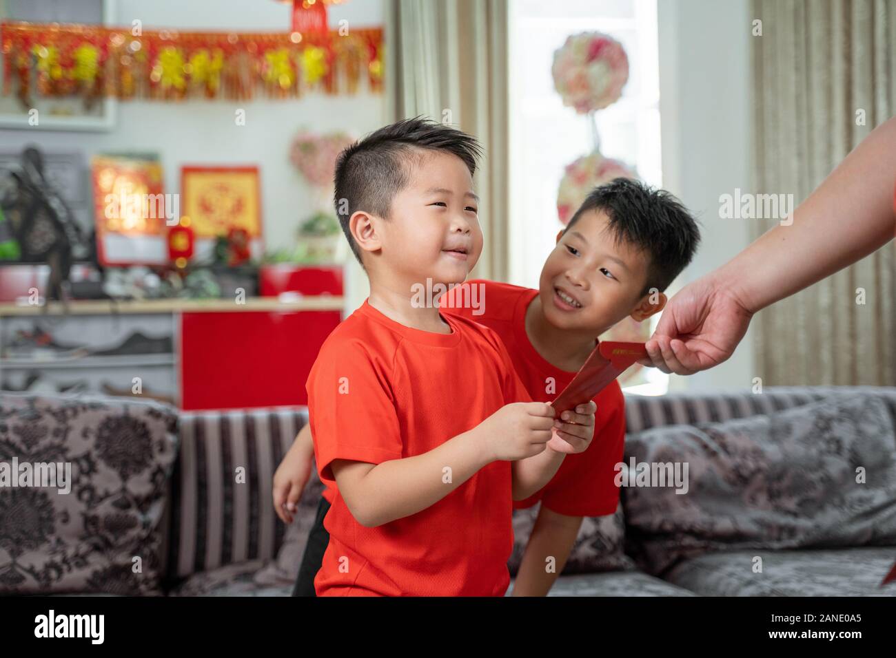 Asian padre dare ang pao a suo figlio Foto Stock