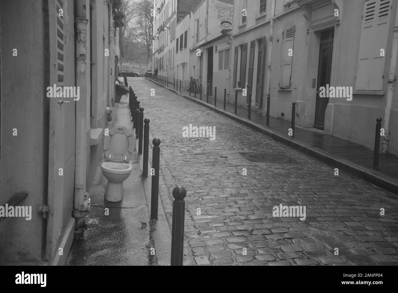 Vista di una tranquilla strada di ciottoli a Parigi con un lavatoio esterno, da pasakdek Foto Stock