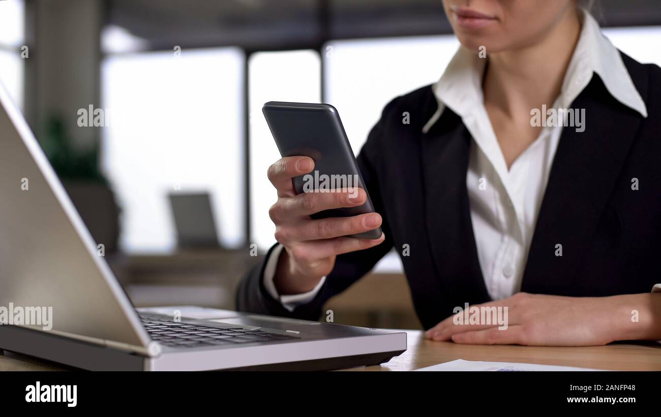 Femmina tramite cellulare in ufficio, concetto di mobile e portatile la sincronizzazione Foto Stock