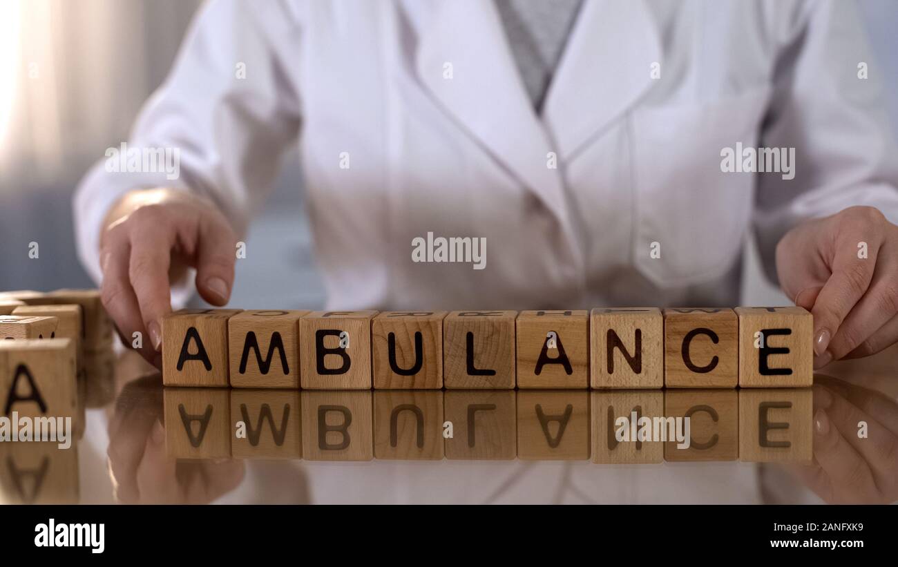 Medico donna rendendo parola ambulanza di cubi di legno, urgente Servizio medico Foto Stock