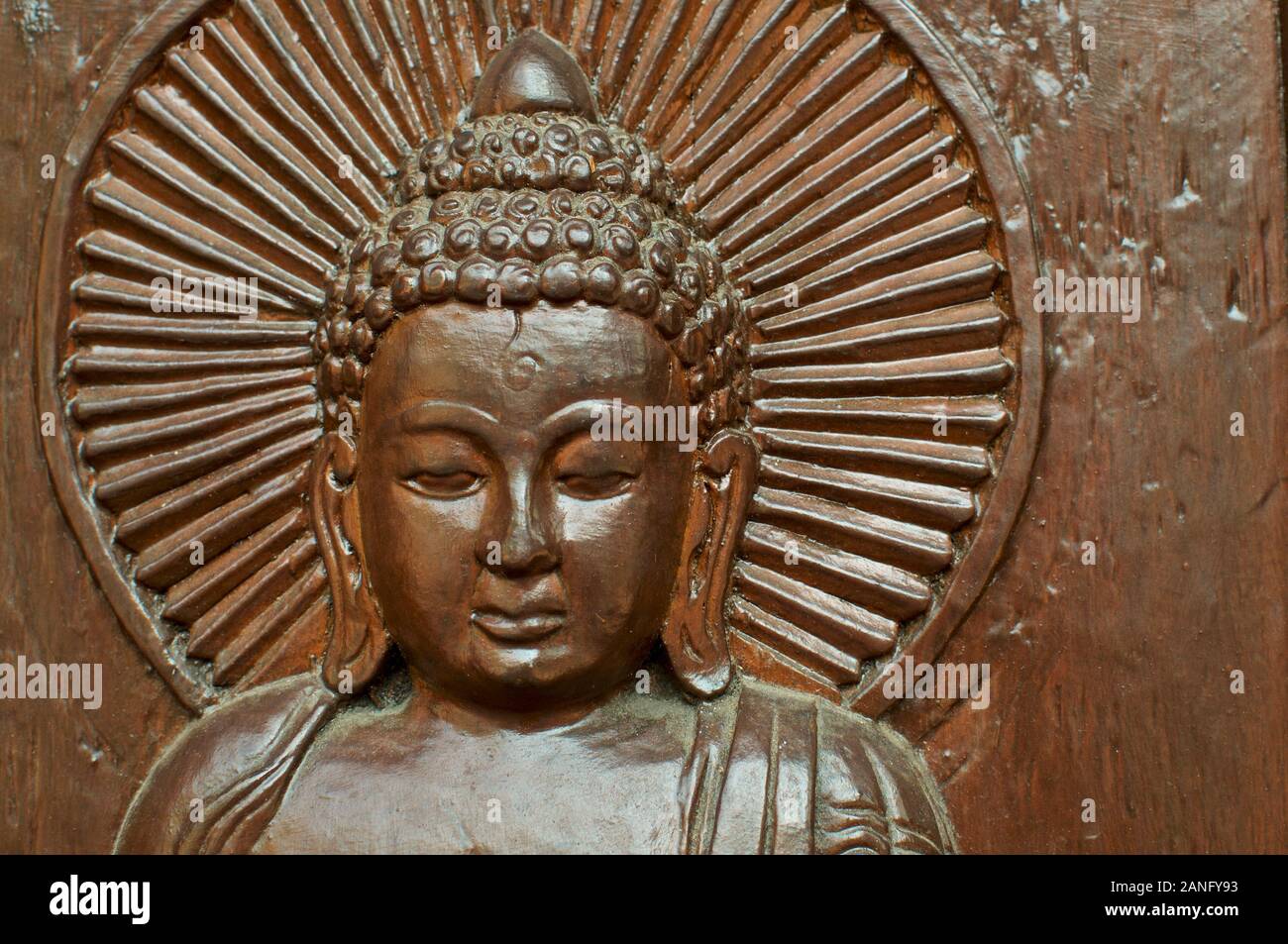 In prossimità di uno in legno intagliato testa di Buddha con un aura mistica intorno alla sua testa. Situato presso il nepalese Pagoda della Pace a Brisbane, South Bank Parklands Foto Stock