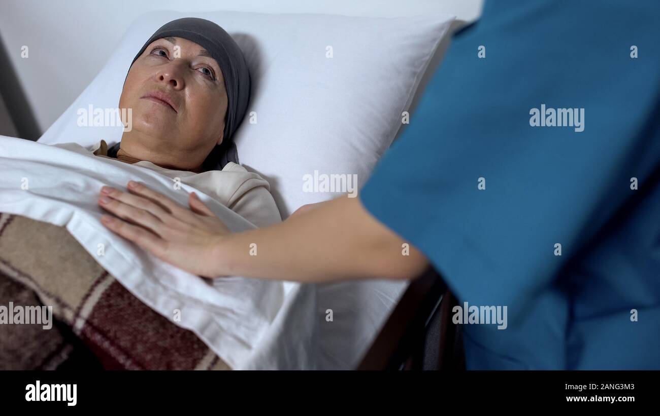 Malato-infermiera copertura paziente senior con coperta, sofferenza il cancro, supporto Foto Stock