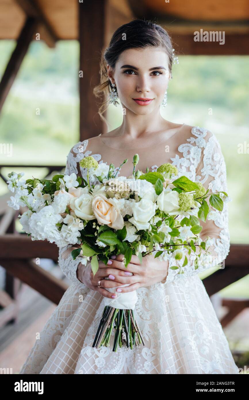 La sposa in un magnifico, bianco abito da sposa con un matrimonio fiori  Foto stock - Alamy