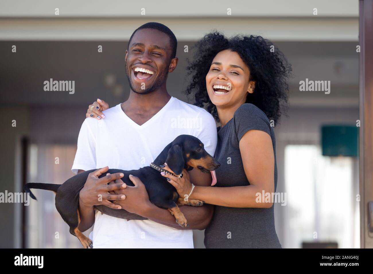 Ritratto di eccitato famiglia nero in posa con il cane vicino a casa Foto Stock