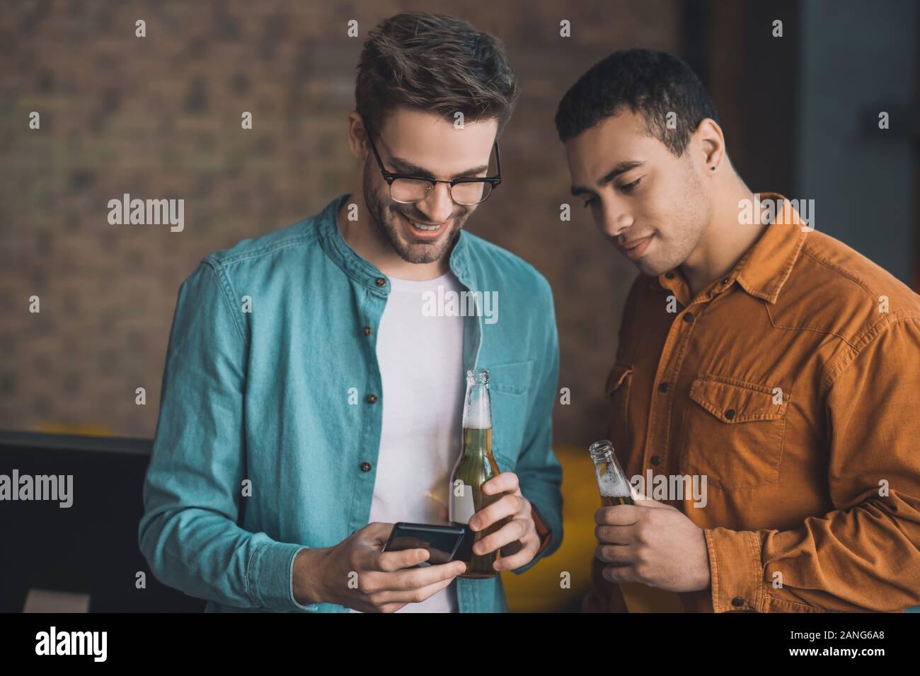 Piacevole uomo felice di bere con il suo amico Foto Stock