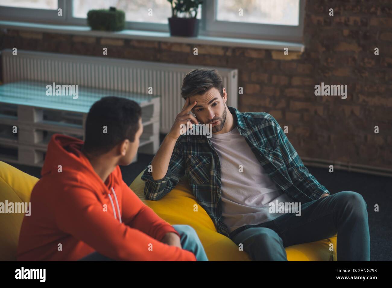 Piacevole uomo barbuto avente una conversazione con il suo amico Foto Stock