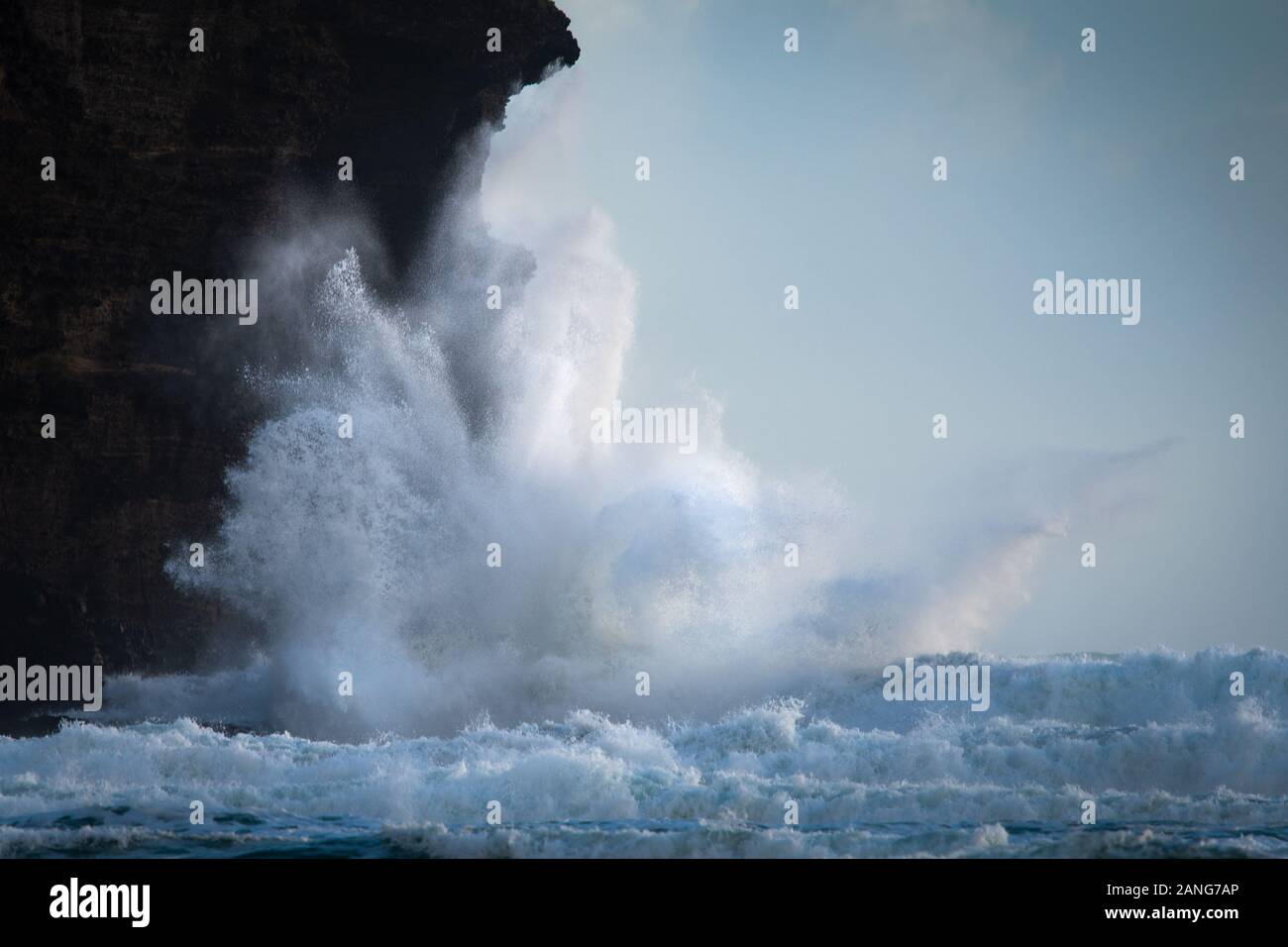 Enormi onde che si infrangono contro gli scogli a Piha Beach, Waitakere, Nuova Zelanda Foto Stock