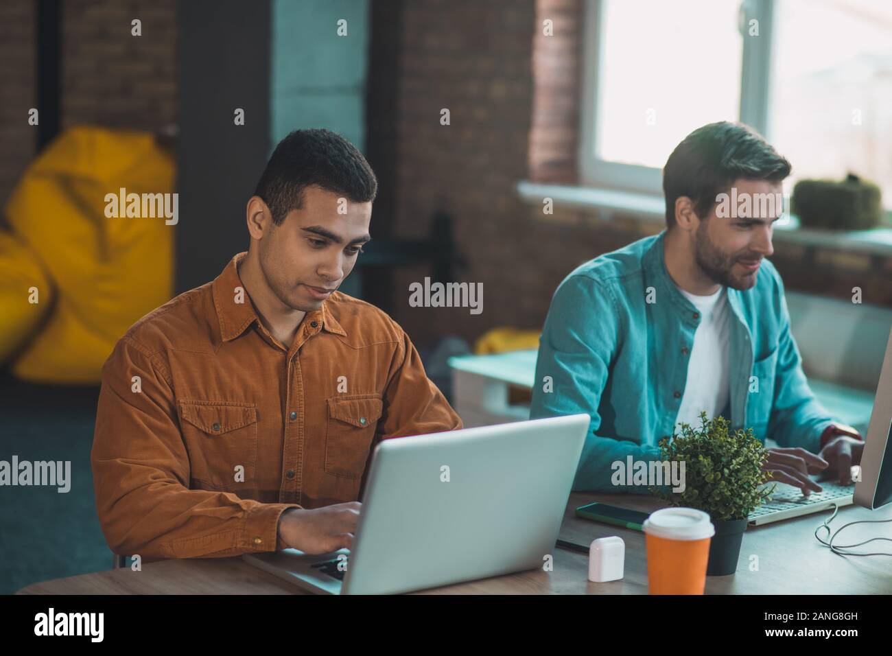 Piacevole giovane guardando lo schermo di tablet Foto Stock