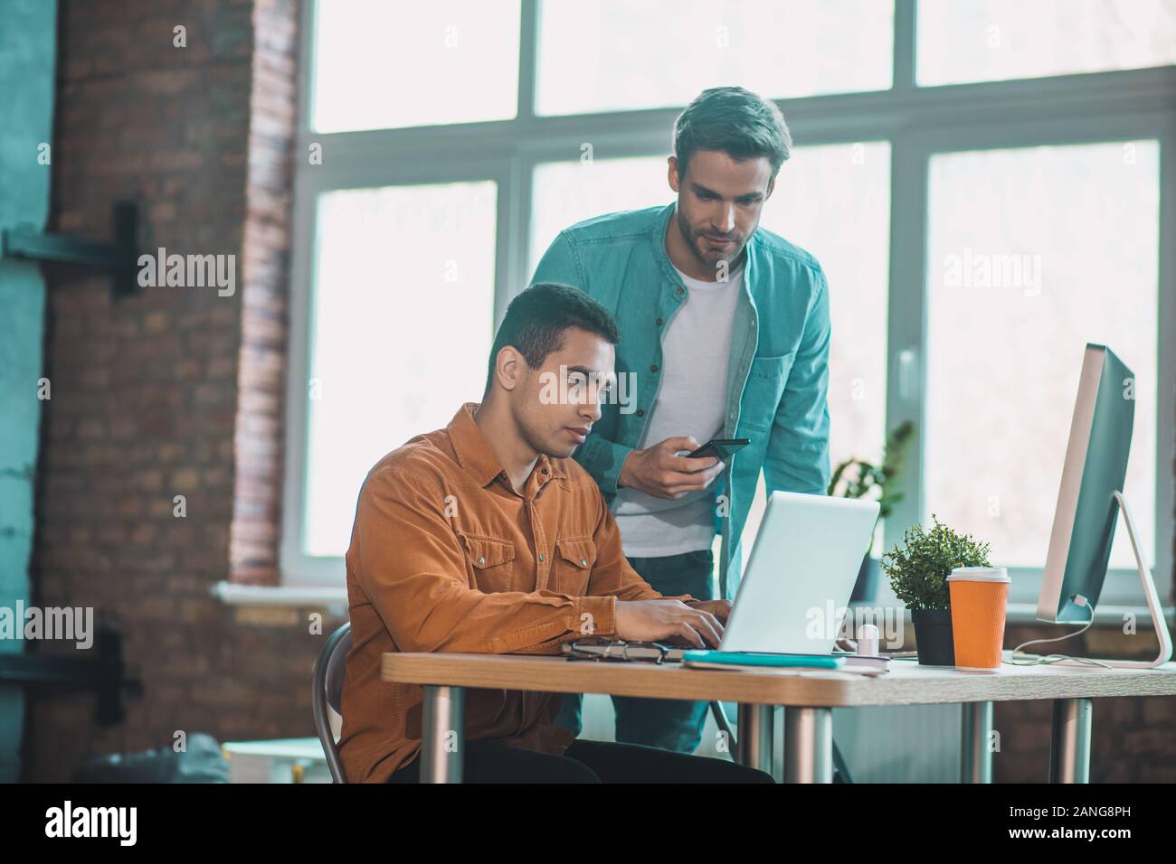 Bella giovane uomo in piedi vicino al suo collega Foto Stock