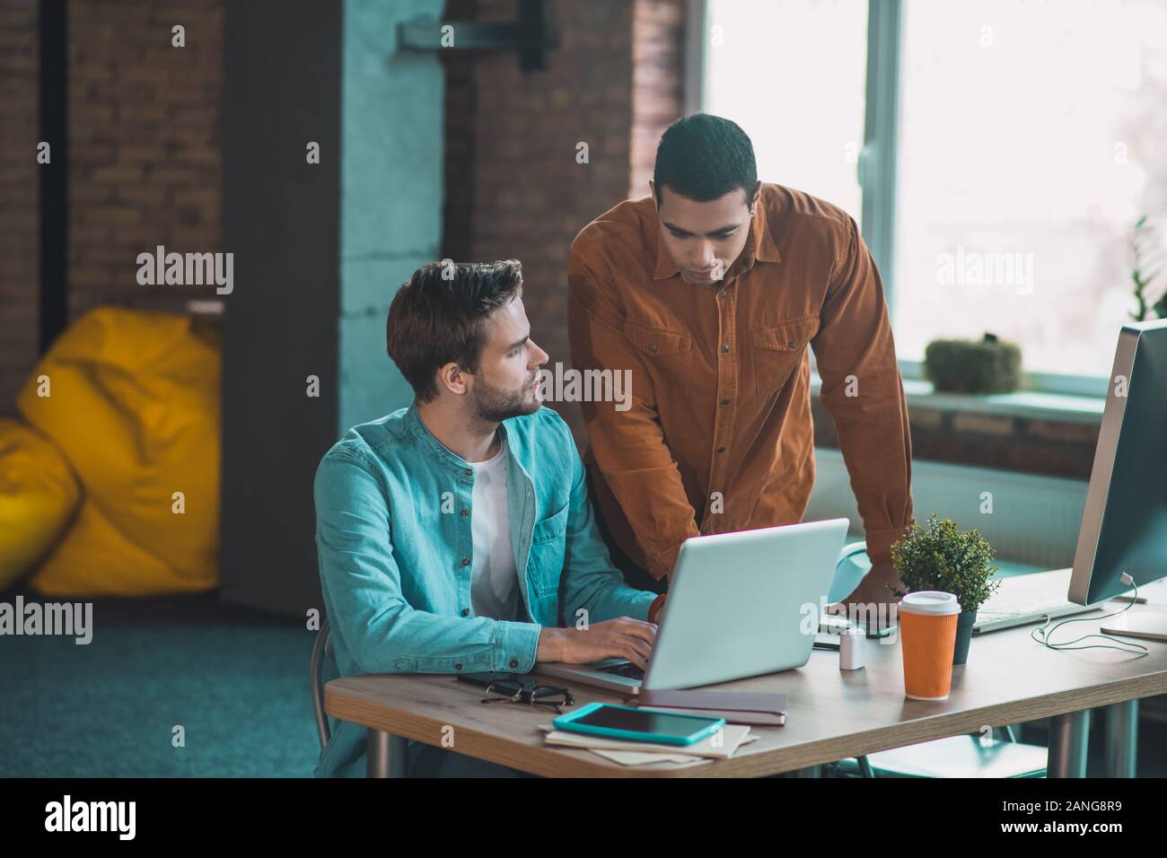 Piacevole uomo adulto a parlare con il suo collega Foto Stock