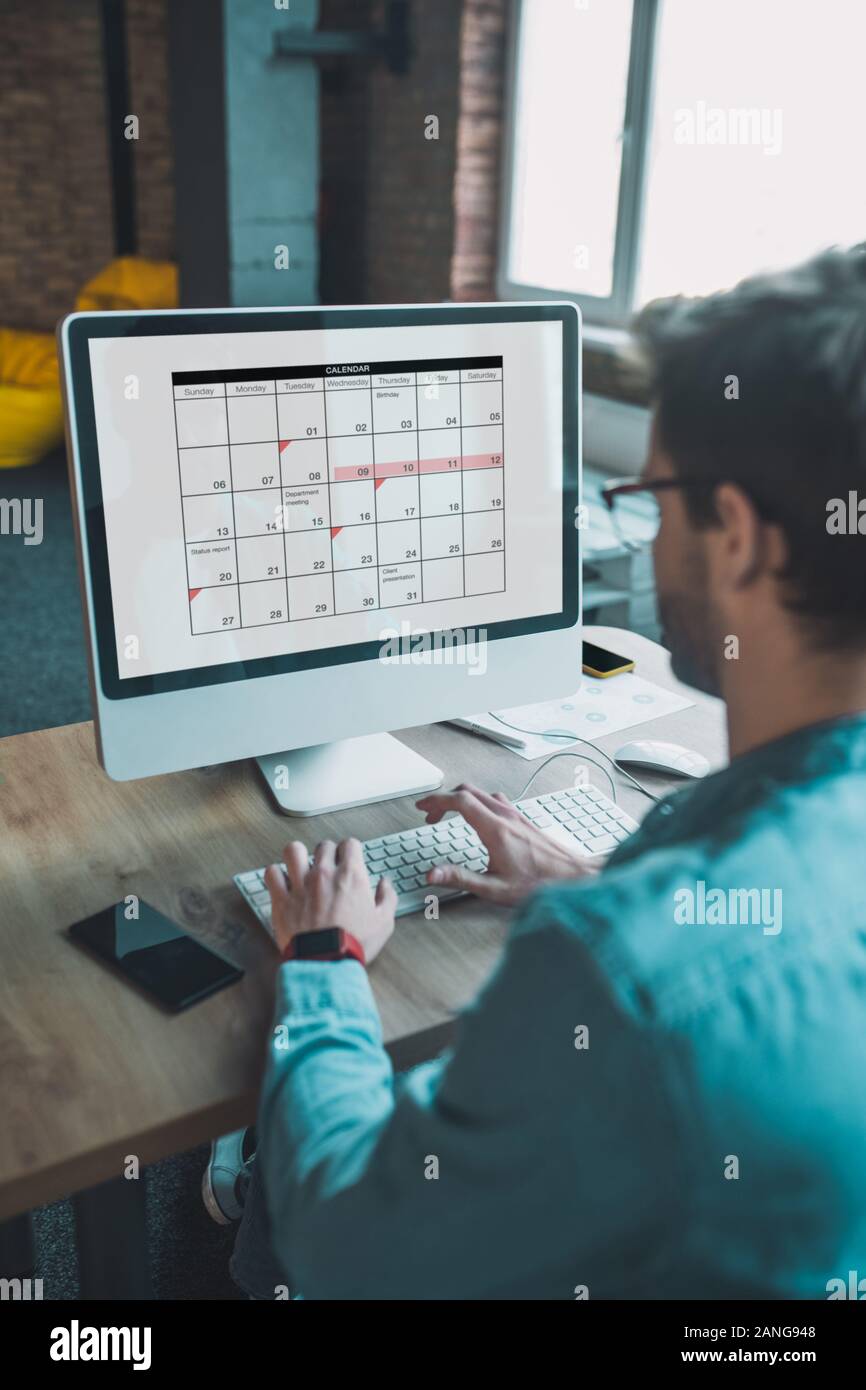 Intelligent bella giovane uomo pianificazione il suo calendario Foto Stock