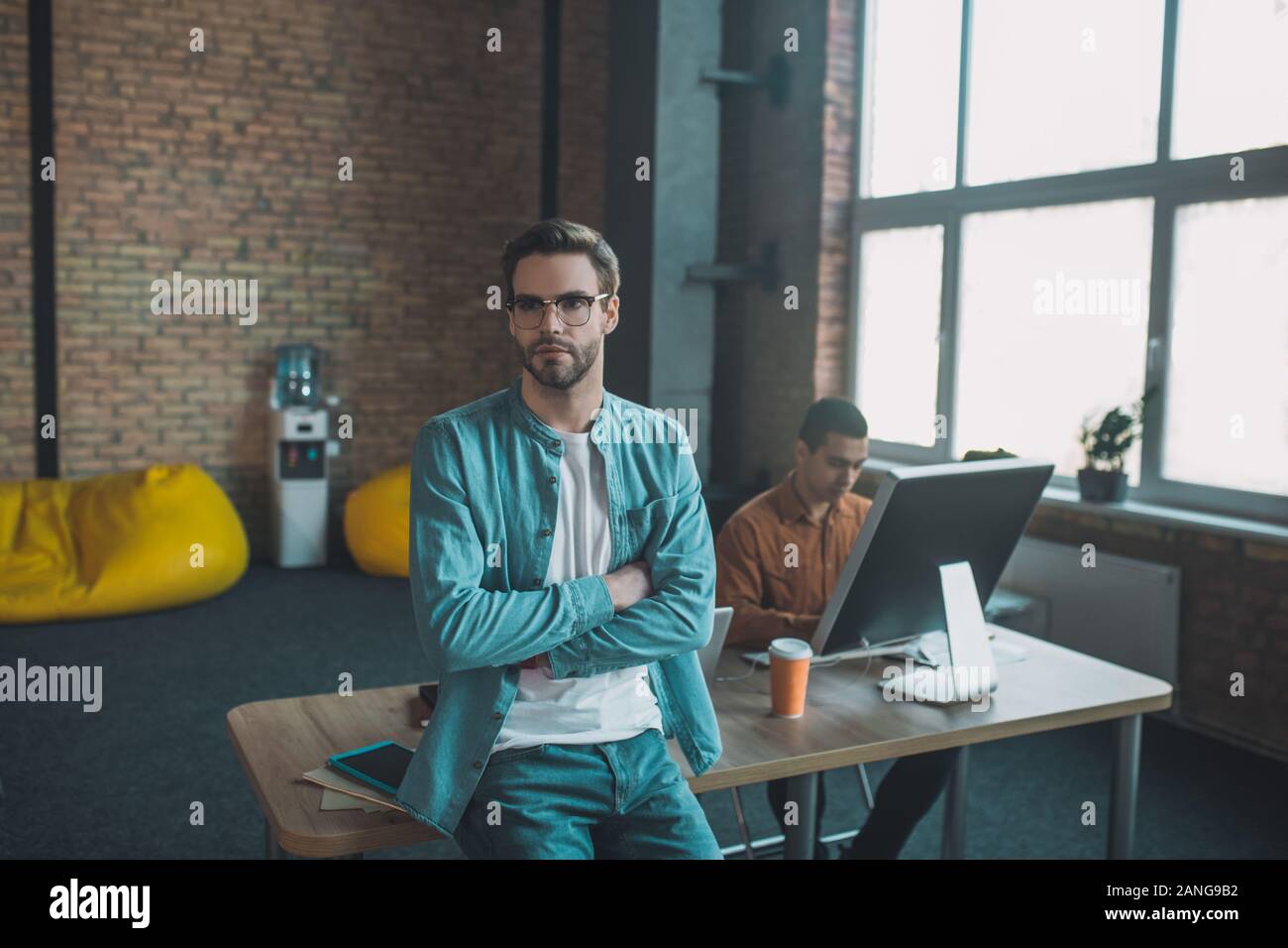 Intelligent barbuto uomo seduto sulla sua scrivania Foto Stock