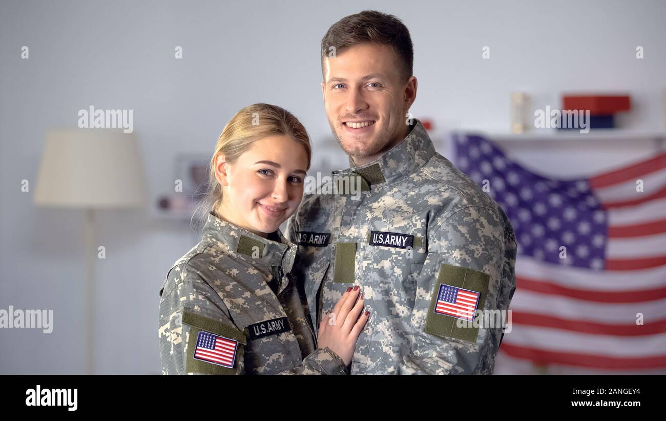 Coppia felice di soldati americani abbracciando e sorridente sulla fotocamera, orgogliosi patrioti Foto Stock