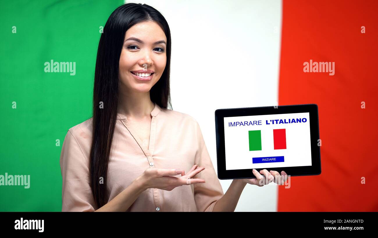 Signora azienda tablet con imparare italiano app, Italia bandiera su sfondo, istruzione Foto Stock