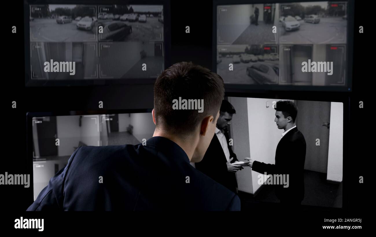 Operatore sicurezza guardando il trasferimento di corrompere sul video TVCC, il concetto di sicurezza Foto Stock