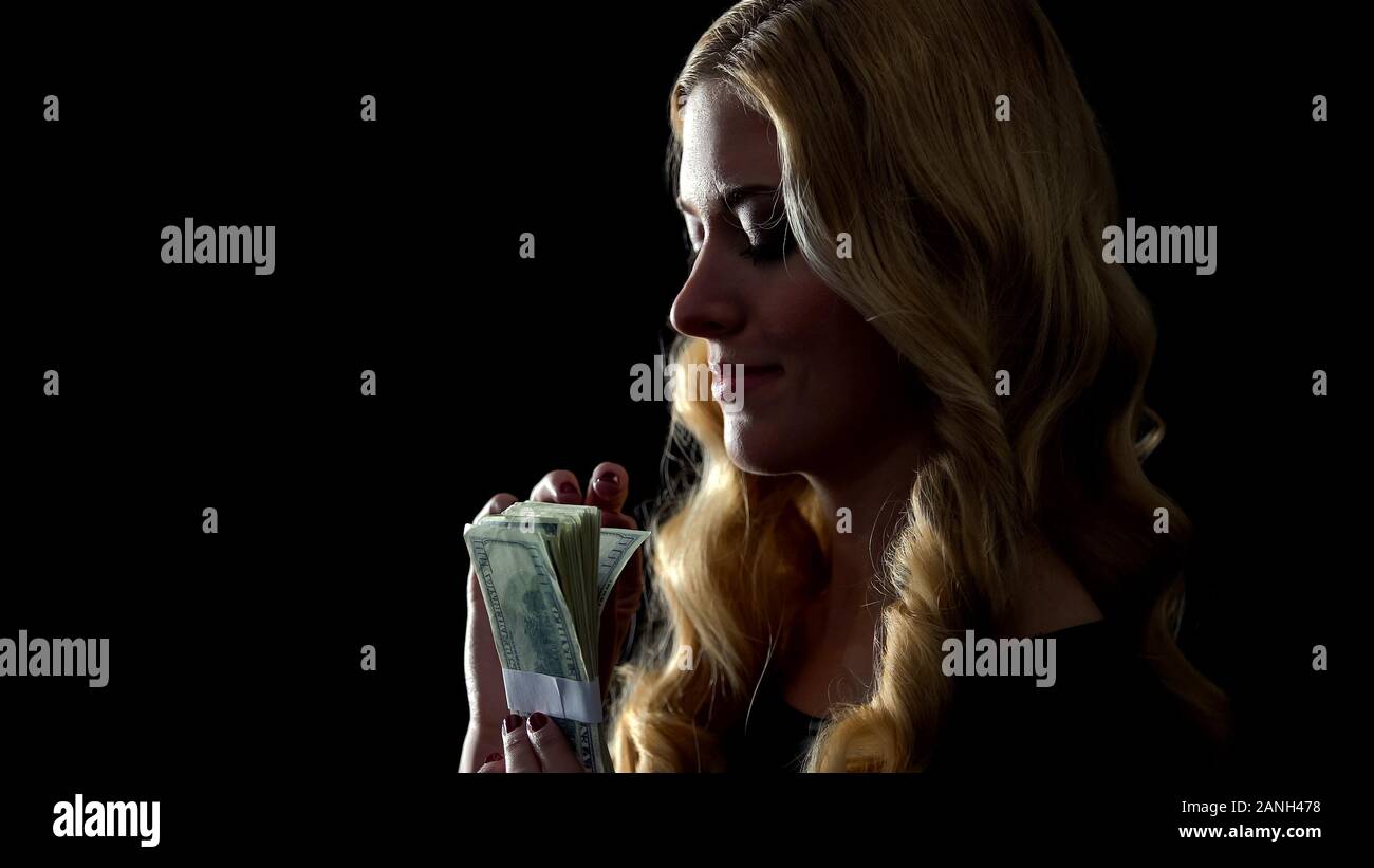 Il piacere lady holding mazzetto di dollari, business illegale deal, denaro servizio lavanderia Foto Stock