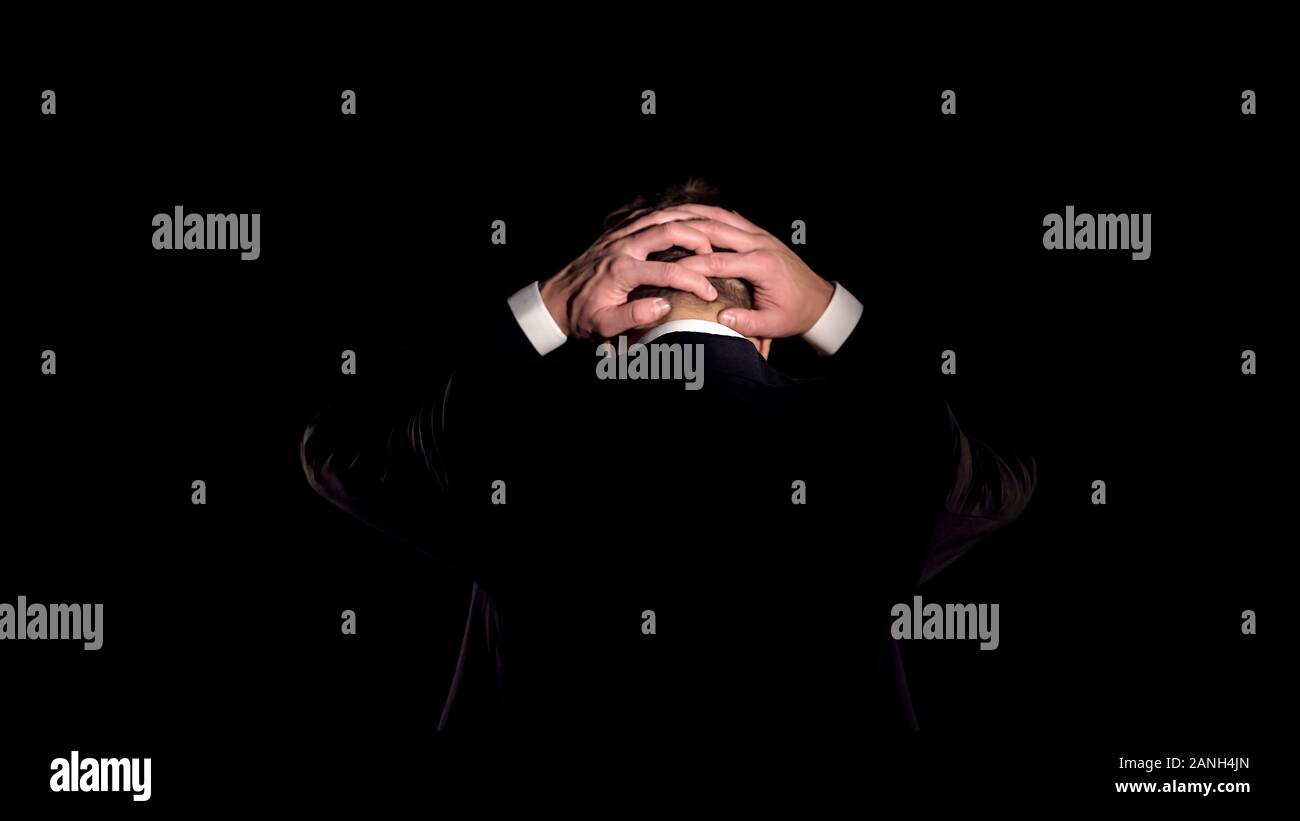 Angry Man in suit tenendo la testa, deplorando business la criminalità, le frodi finanziarie Foto Stock