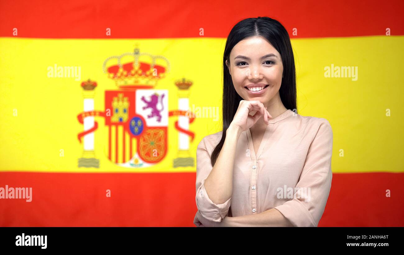 Bella Donna che guarda la fotocamera contro Spanish flag di sfondo, il turismo Foto Stock