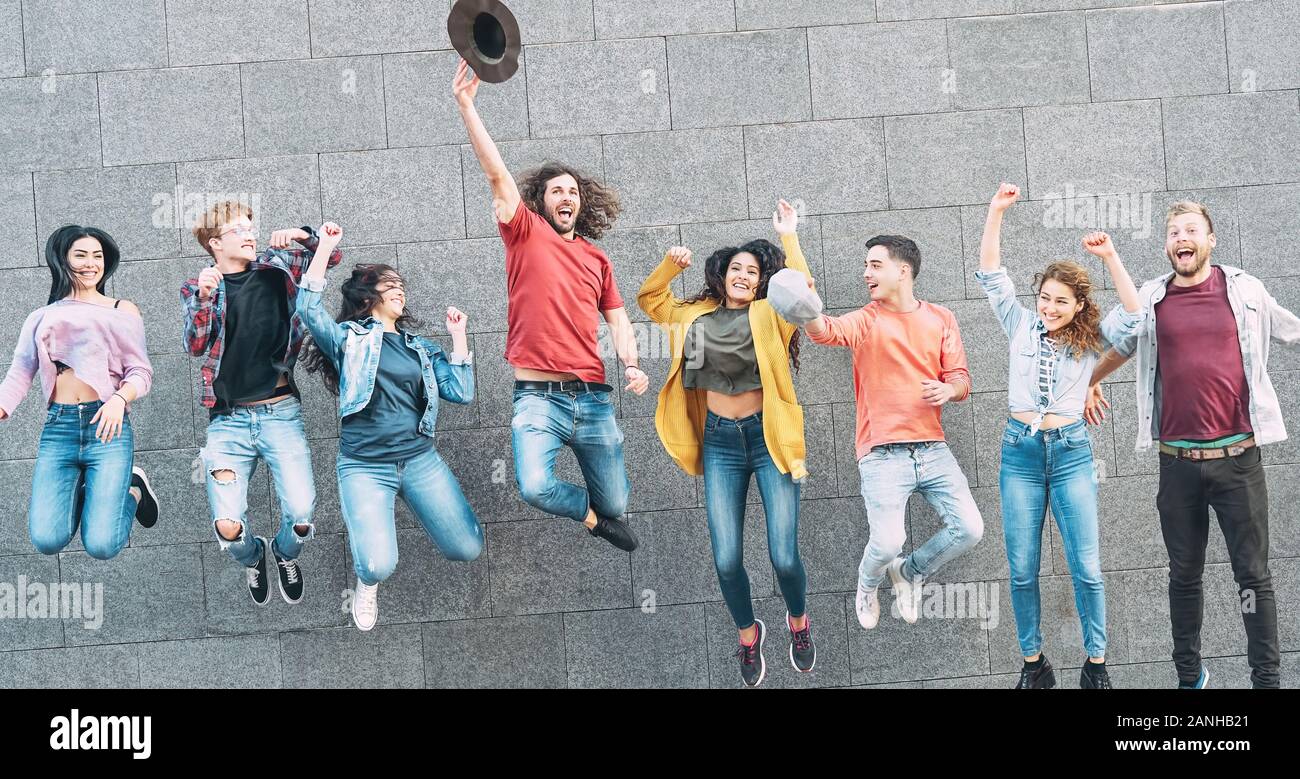 Un gruppo di giovani persone che saltano insieme all'aperto - Happy amici millenario celebra il successo in college Foto Stock