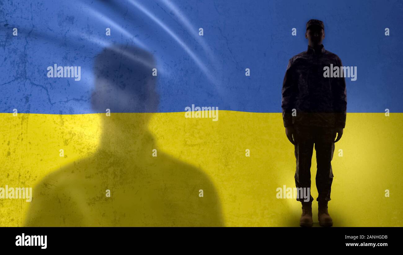 Soldato ucraino silhouette in piedi contro la bandiera nazionale, orgoglioso esercito sergente Foto Stock