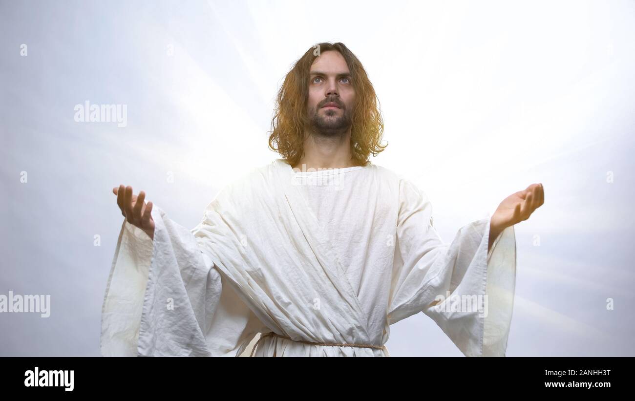 Gesù alzando le mani al cielo su sfondo illuminato, risurrezione holiday Foto Stock