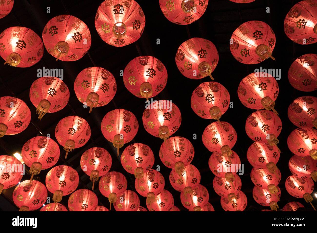Un gruppo di lanterne rosse sul soffitto. Ogni lanterna ha alfabeti cinesi che significano desiderio di buona fortuna e felicità. Foto Stock