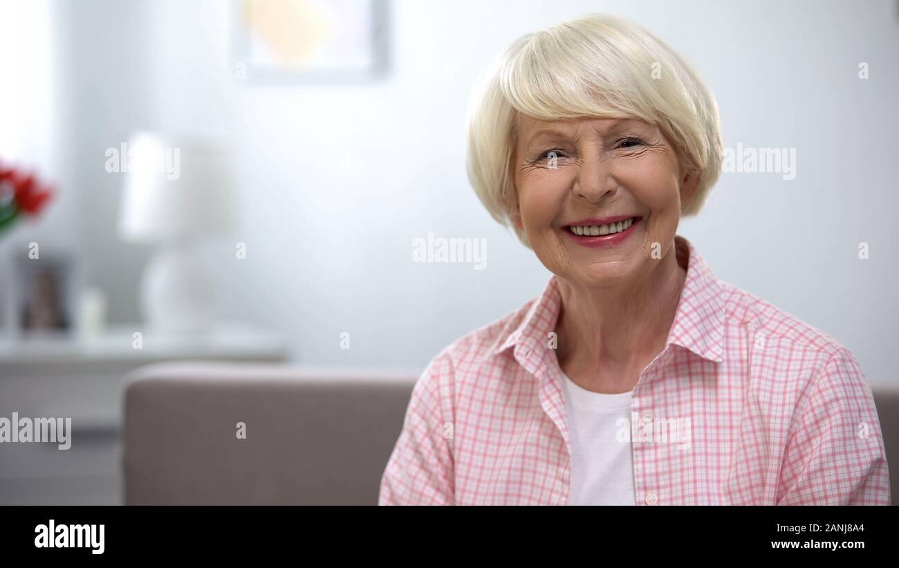 Felice anziani donna sorridente alla fotocamera, la sicurezza sociale, i benefici previdenziali Foto Stock