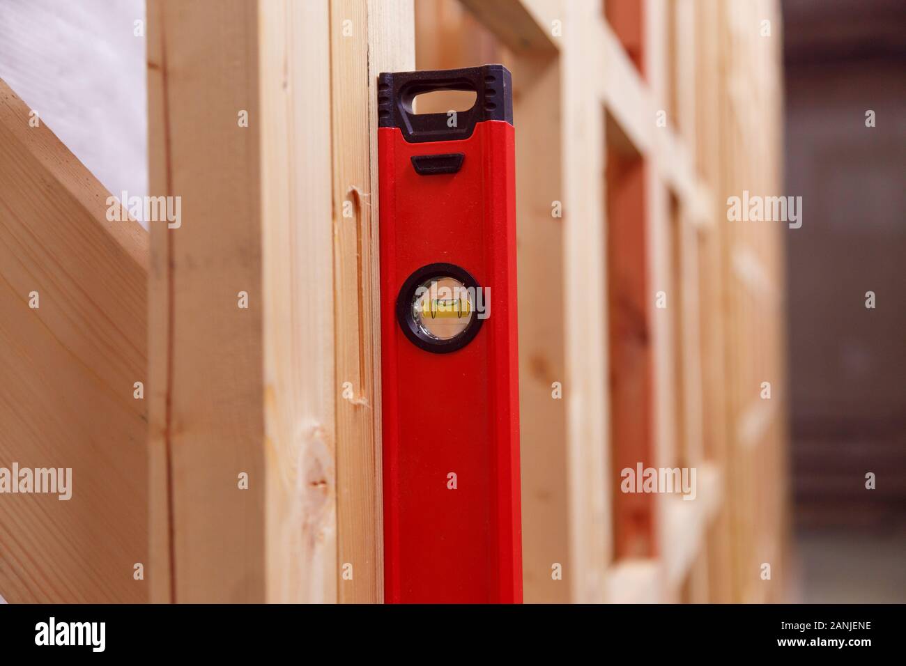 Il controllo di qualità della costruzione in legno strutture di costruzione di una casa di telaio. Misura della deviazione verticale di strutture installate. Foto Stock