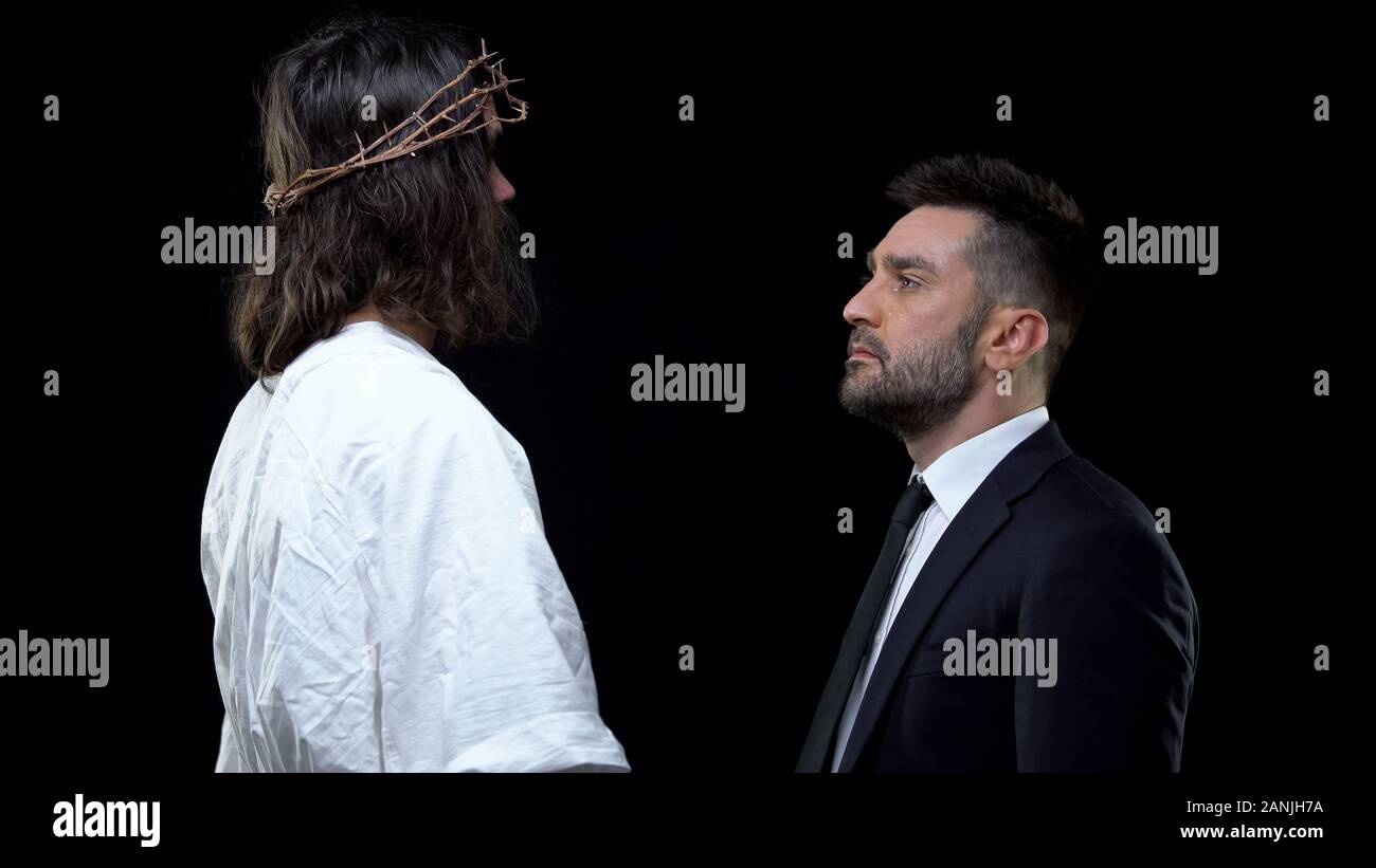 Maschio di pianto guardando il Messia nella corona di spine su sfondo scuro, supporto Foto Stock