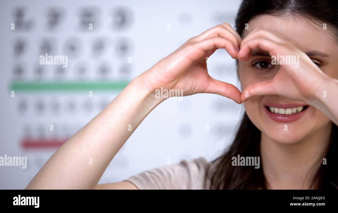 Allegro lady paziente rendendo il cuore delle mani, soddisfatto un successo chirurgico, cura Foto Stock
